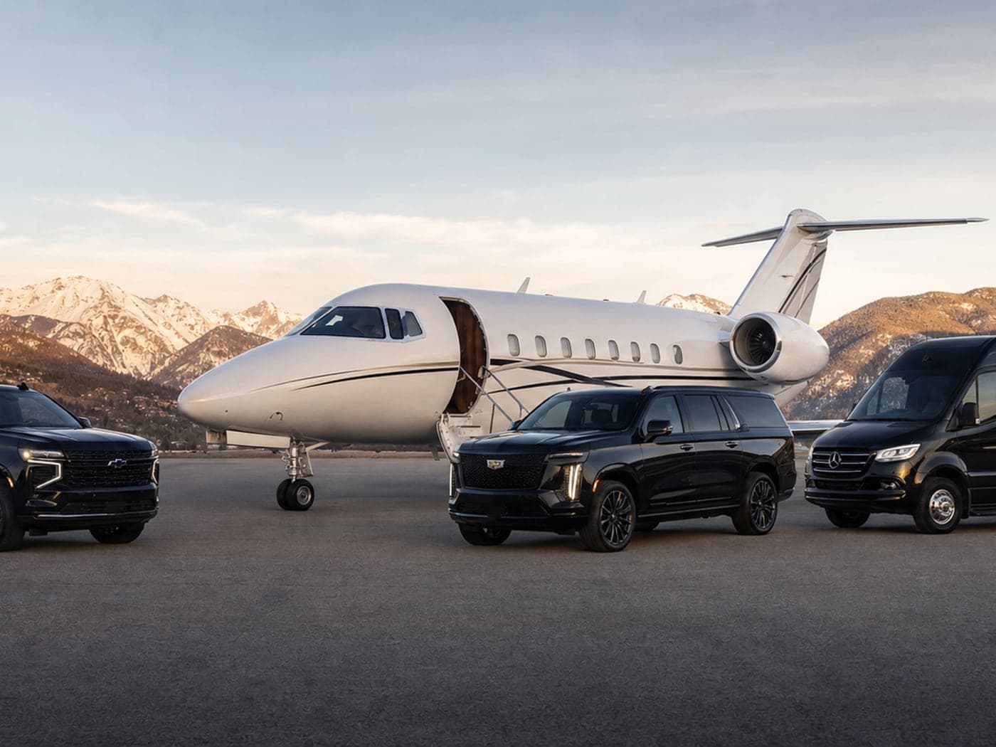 Black executive fleet staged with a private jet — premium ground service for Boulder travel.