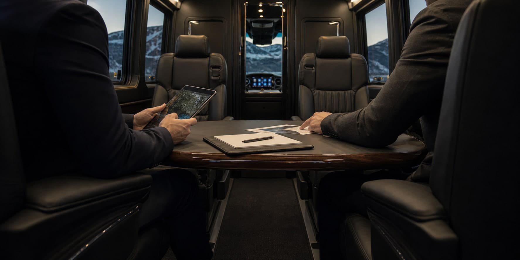Executive Sprinter interior with a meeting table and captain's-chair seating.