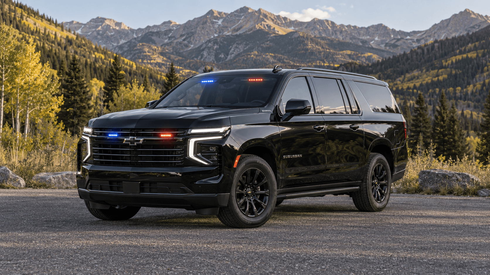 Black SUV with red and blue grille and windshield lights parked at a mountain overlook below jagged peaks.