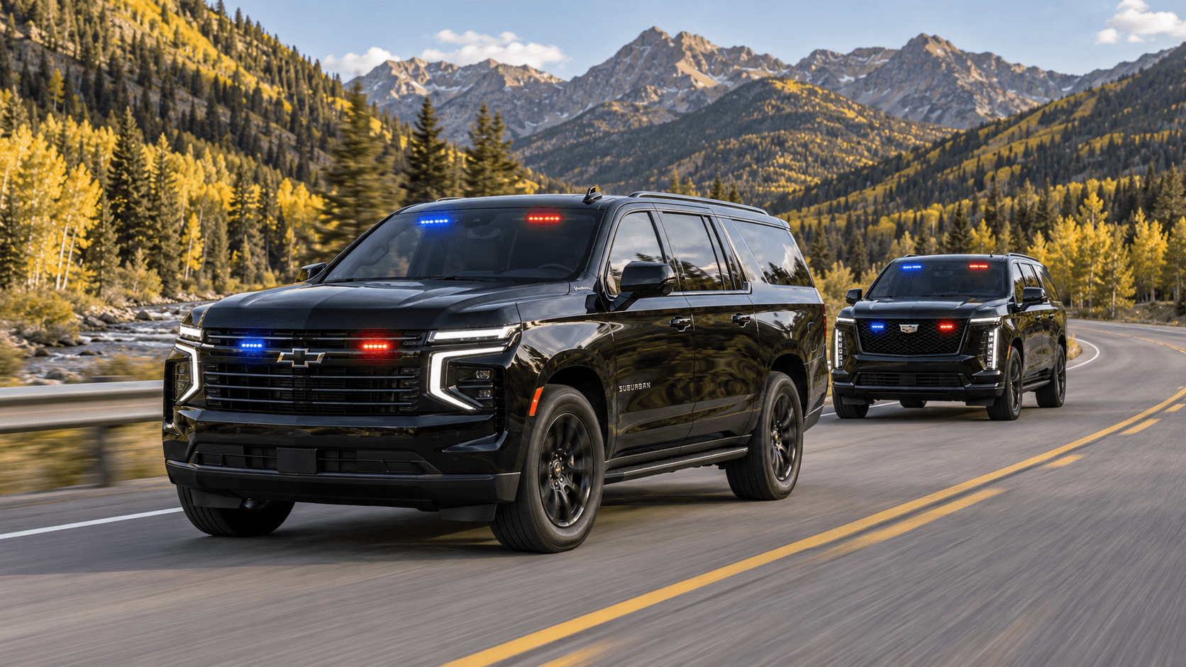 Two black SUVs with red and blue grille and windshield lights moving together on a mountain highway beside a river.